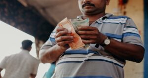 An Indian man counting his notes