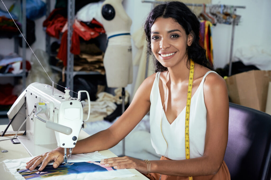 A woman business owner standing in front of her tailoringshop