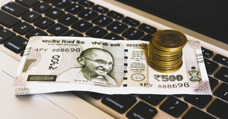 Indian money sitting on a laptop