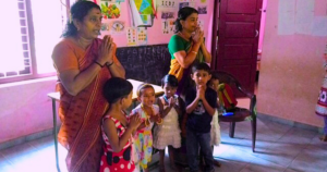 Anganwadi wroker, helper and children begin the day with a prayer