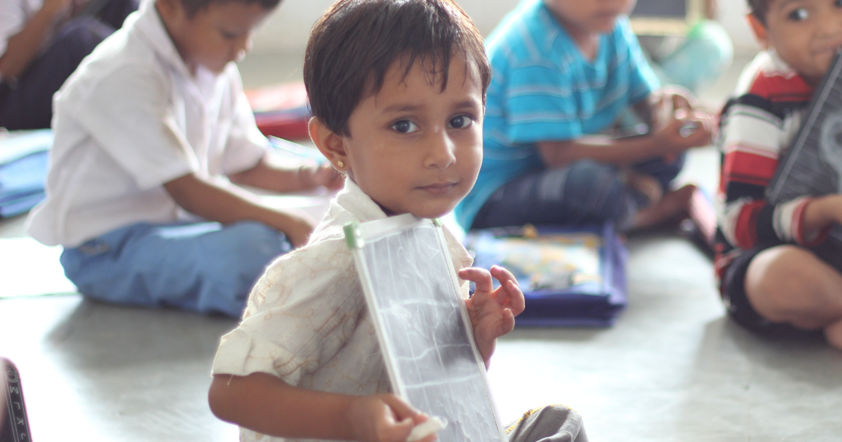 Child writing on a slate in pre-school