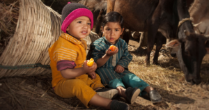Young children eating fruit.