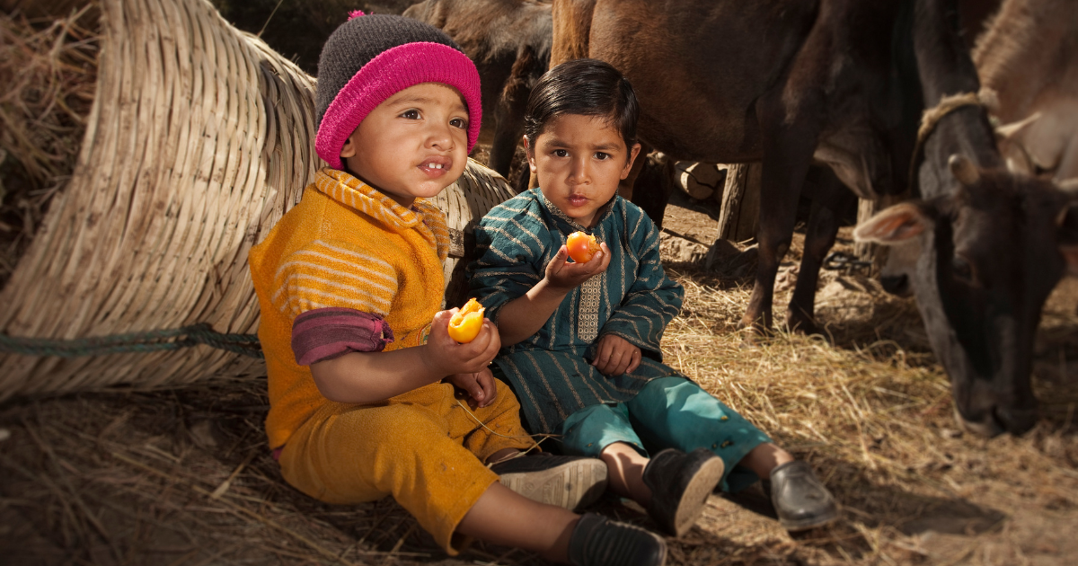 Young children eating fruit.